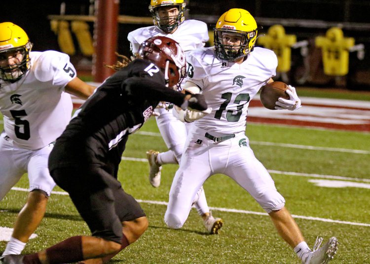 (Brad Davis/For LootPress) Greenbrier East's Lucas McCallister carries the ball as Woodrow Wilson defender Elijah Redfern converges on him Friday night in Beckley.