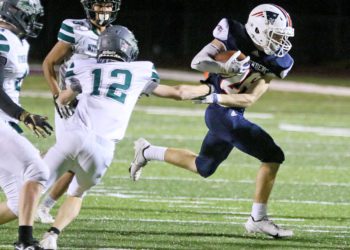 (Brad Davis/For LootPress) Independence's Tyler LInkswiler carries the ball as Wyoming East defender Kaiden Weaver (#12) tries to tackle him Friday night in Coal City.