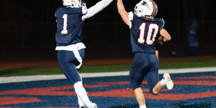 Independence's Trey Bowers (left) and Judah Price (right) high five after Price scores on a punt return Nov. 12 in Coal City. (Heather Belcher/Lootpress)