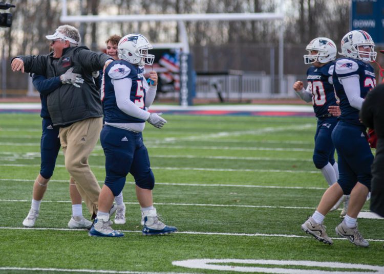 Independence offensive line coach Kevin Grogg (left) rushes the field following the team's 34-20 win over Bluefield on Nov. 26 in Coal City (Heather Belcher/Lootpress)