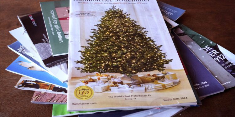 A collection of 2024 holiday catalogs are displayed Monday, Nov. 25, 2024, in Freeport, Maine. Catalog retailers, reeling from U.S. postal rate increases, have responded with pint-sized catalogs this holiday season. (AP Photo/Robert F. Bukaty)