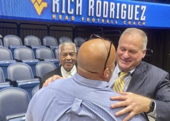 West Virginia coach Rich Rodriguez hugs a fan following his introductory NCAA college football news conference Friday, Dec. 13, 2024, in Morgantown, W.Va. (AP Photo/John Raby)