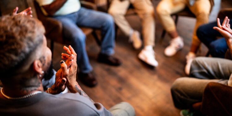 Men applauding in group therapy at mental health center